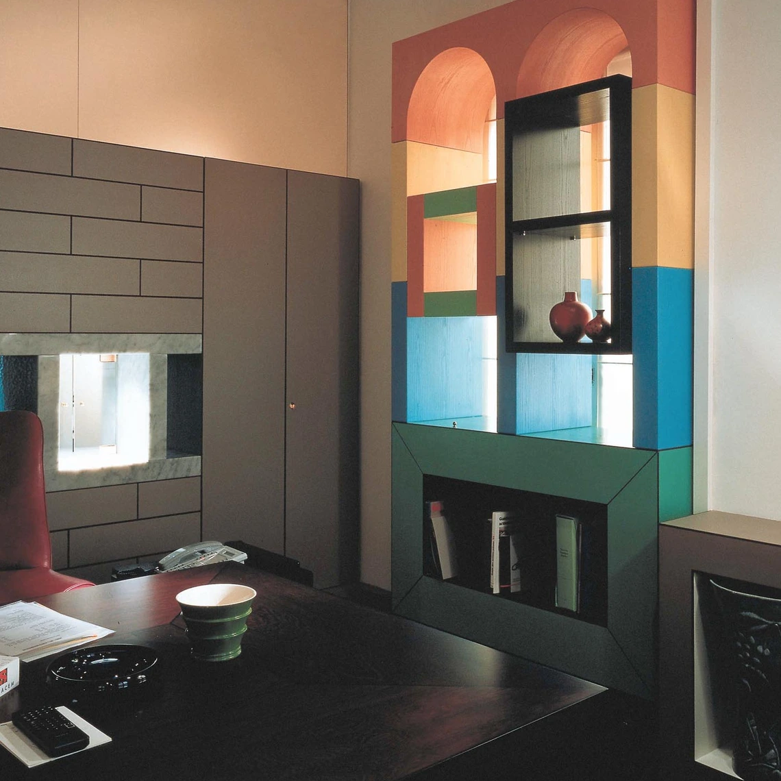 Office of Cementeria di Merone. An interior with a cupboard and a table
