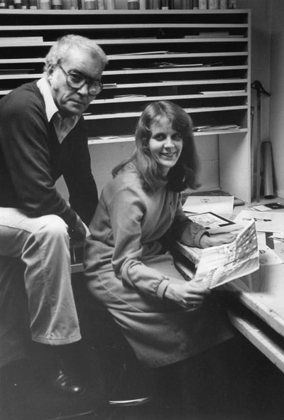 Sally Cruikshank and a sitting man wearing glasses