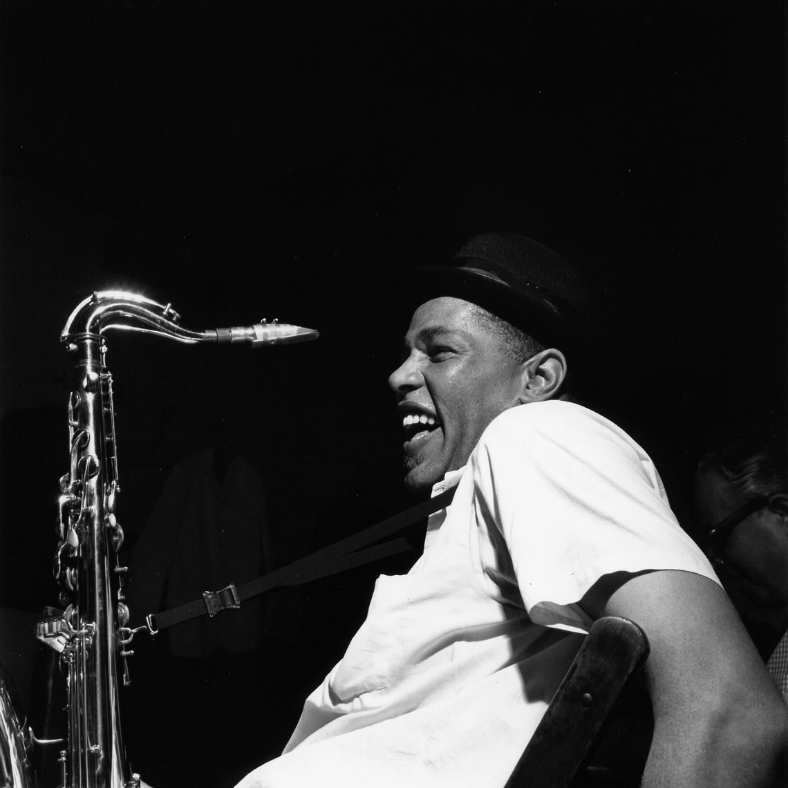 Dexter Gordon sitting with his saxophone. Photo by Francis Wolff