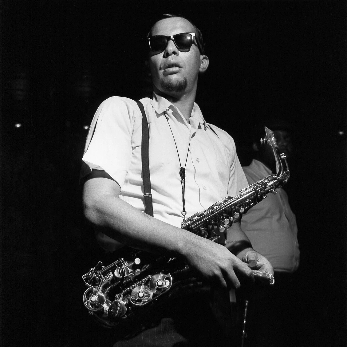 Jackie McLean wearing sunglasses with a saxophone