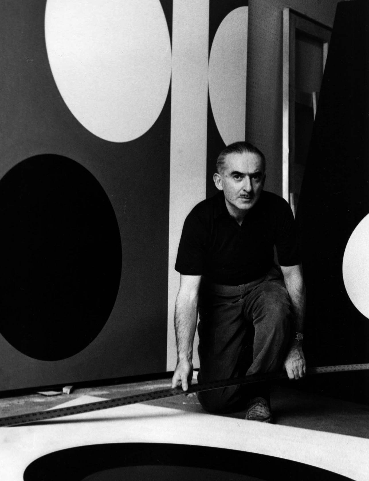 Alexander Liberman on his knees looking into camera