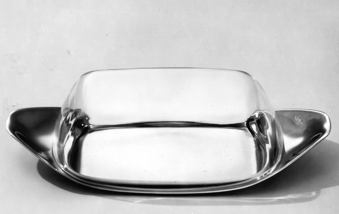 Butter dish designed by Wilhelm Wagenfeld. A metal dish with a glass transparent cup