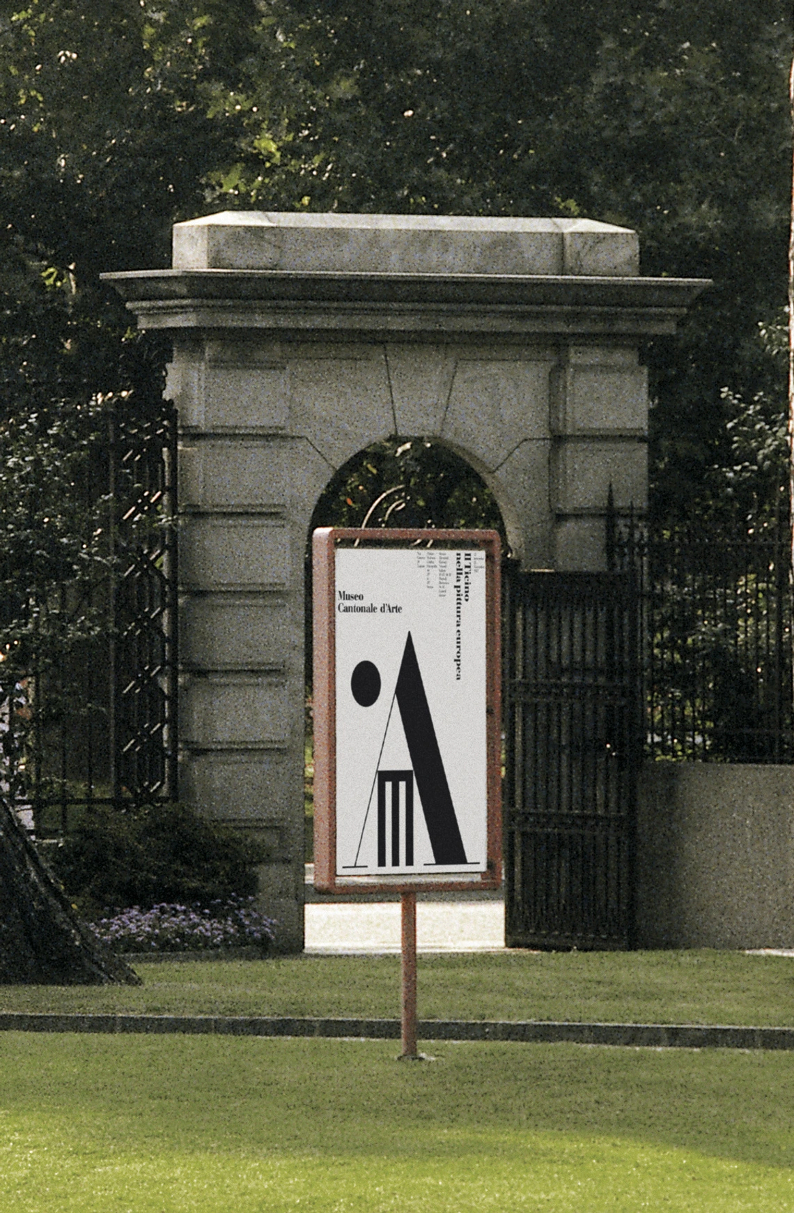 A poster with black letters M and A on a white background, standing in a park