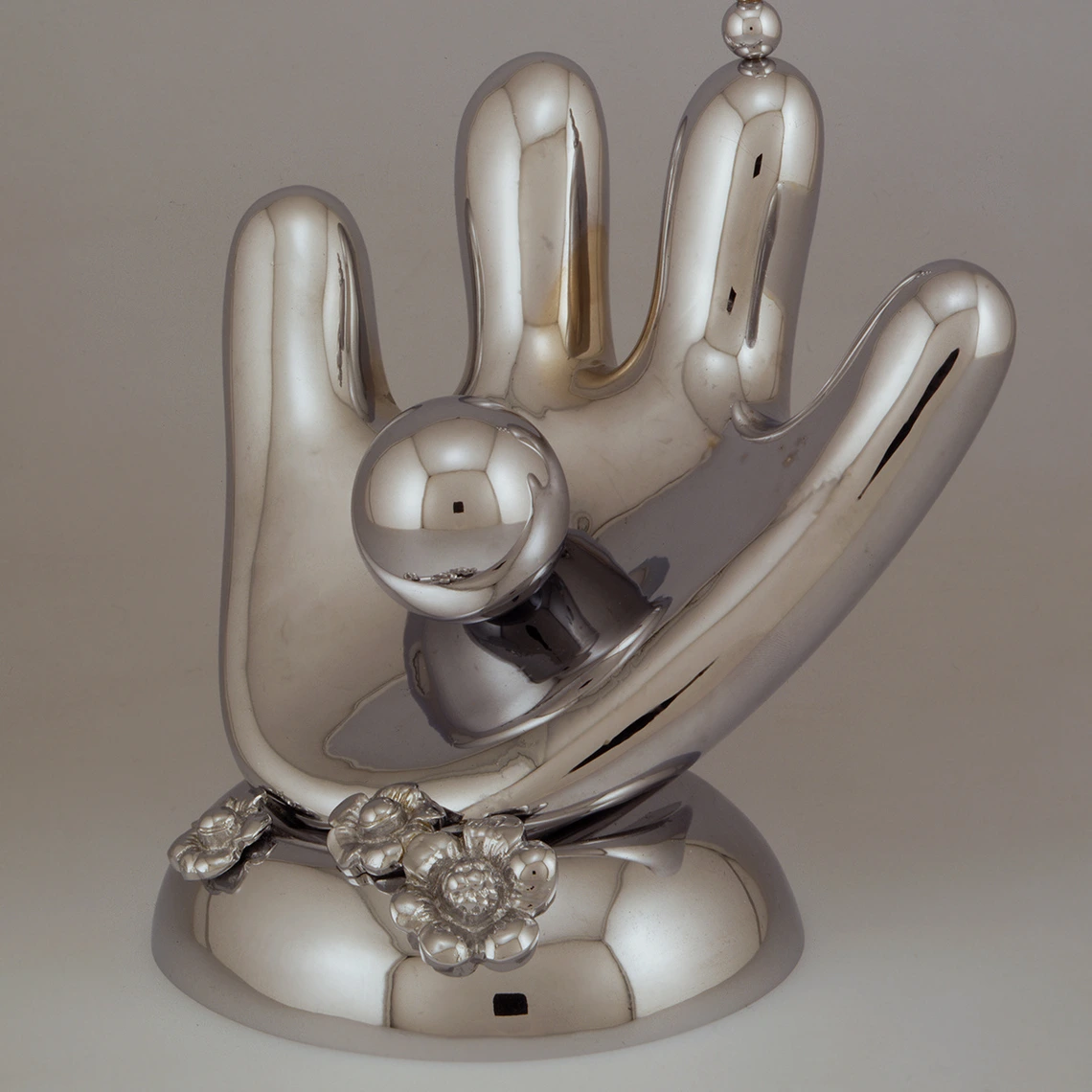 Handoid installation. A metal hand with four fingers, holding a sphere