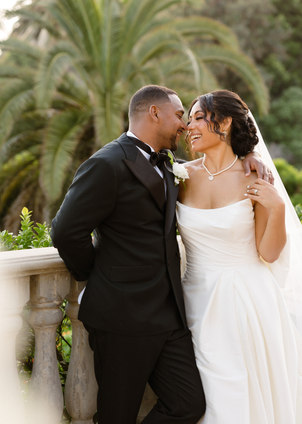 Bride and groom sharing an intimate kiss with an iconic Los Angeles sunset visible in the distance. Los Angeles wedding photography.