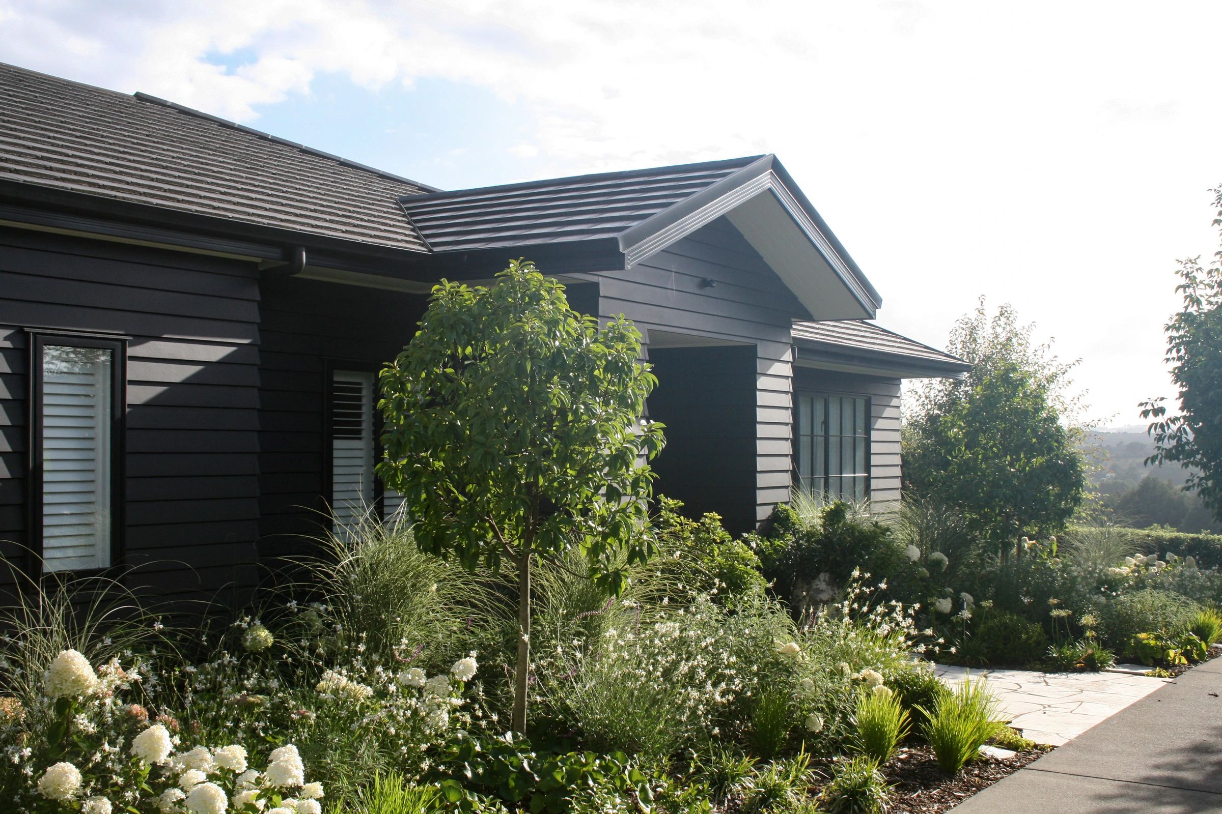 Pukekohe: stone paving through grasses in a family garden, south Auckland