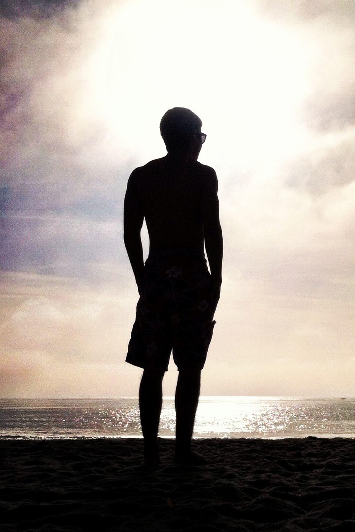 Silhoette of a person watching the sunset at the beach