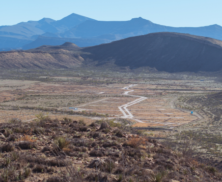 Vista panorámica del paisaje en SIERTO con montañas en el fondo y un camino serpenteante que cruza el valle