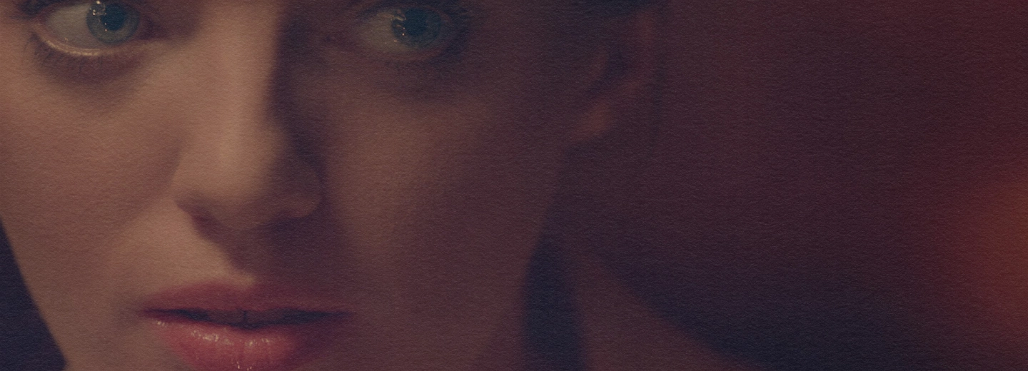 A tight, shallow-depth-of-field close-up from the film 'Cella,' highlighting the emotional expression and striking green eyes of the lead actress.