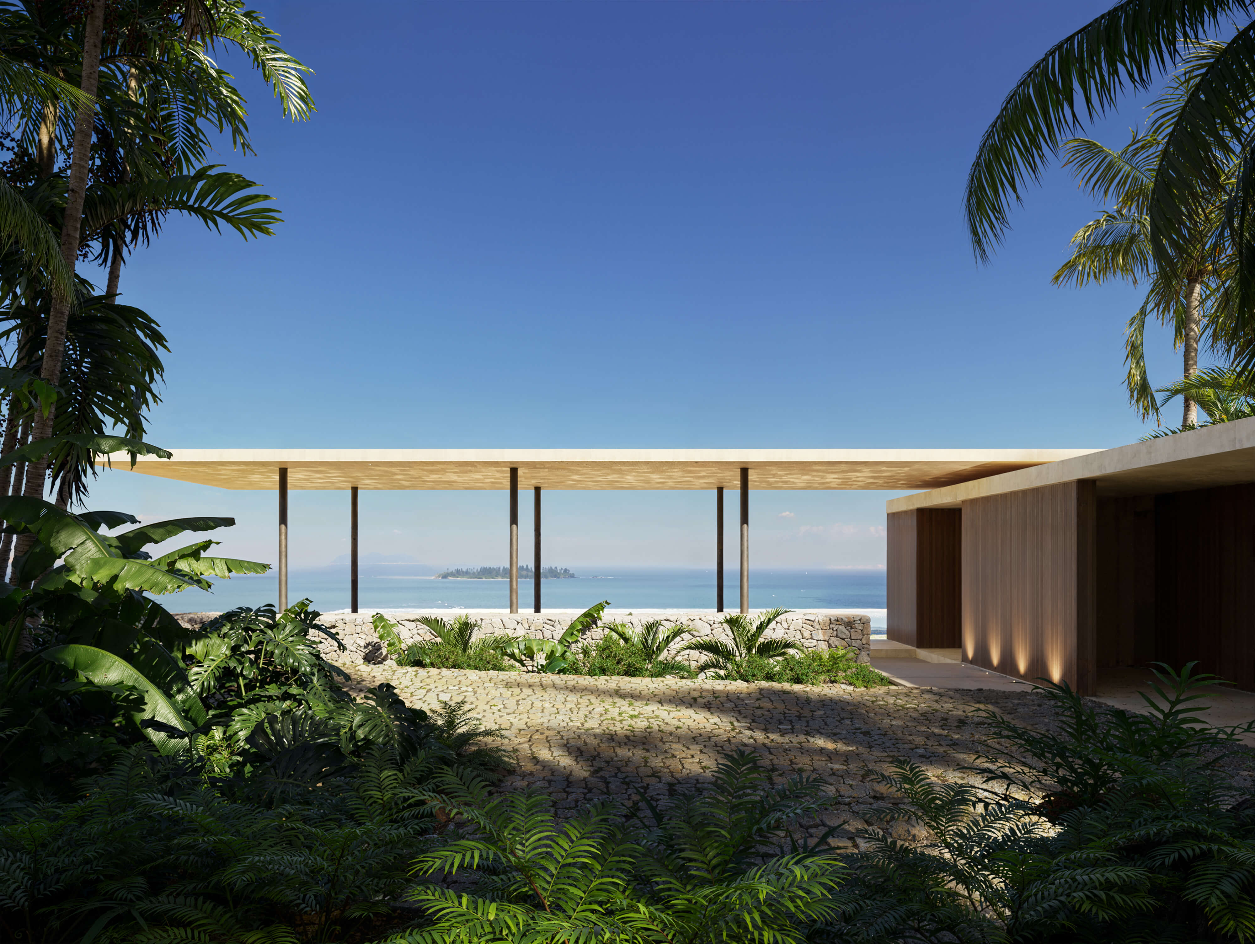 Daytime CGI of Puerto Rico Residences, 2024 by KoDA, USA — minimalist coastal home with stone pathway, tropical landscaping, and open pavilion roof framing ocean views and a distant island.