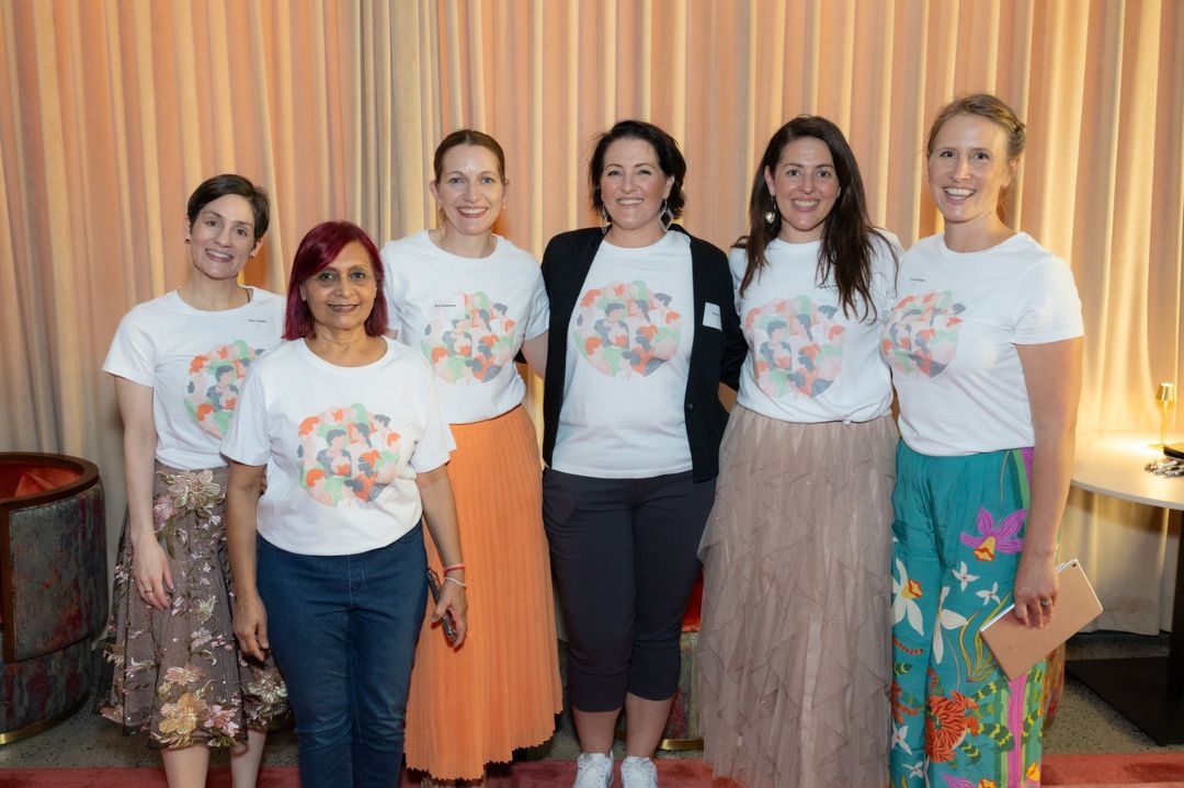 The Franklin Women team standing together and smiling at an event, wearing Franklin Women T-shirts.