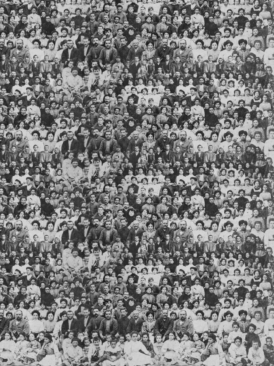 Velvet tapestry printed with a patterned collective portrait, hanging from a found wooden branch in the textile colony landscape
